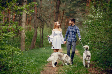 Couple in a forest. Pair with cute dogs. Lady in a white dress