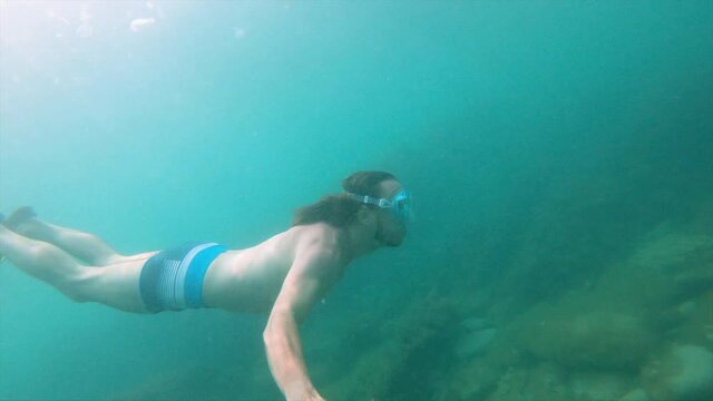 A selfie shot underwater by a Caucasian man sporting a physique floats beautifully underwater. The concept of free diving and recreation on the sea coast or on the ocean
