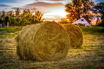 Strohballen auf einem Feld mit Sonnenuntergang