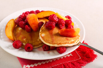 Raspberry and peach pancakes served