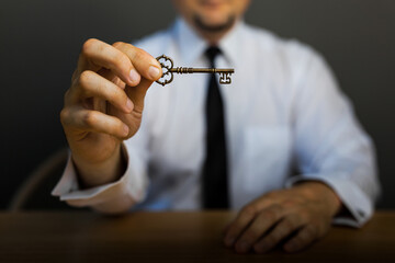 Key to success in businessman hand on background of the sky.