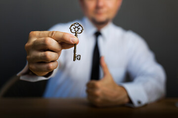 Key to success in businessman hand on background of the sky.