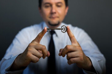 Key to success in businessman hand on background of the sky.