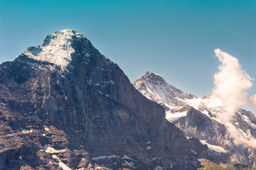 The Eiger north face and snow capped peak, in the background the top of Jungfrau on a bright day in summer. Grindelwald - Bernese Oberland - Switzerland