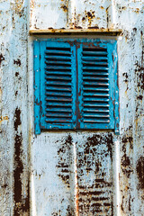 Old wooden window painted blue with rusty lock. Texture, wall of an old wooden house with shuttered windows, painted blue. 