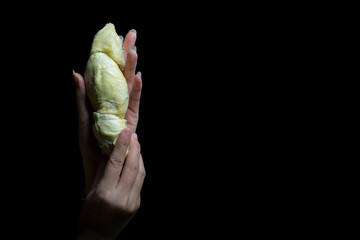 Woman's hand holding durian on black background