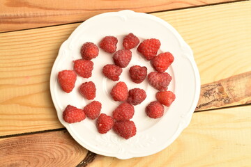 Juicy organic raspberries, close-up, on a wooden table.
