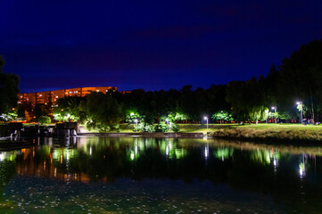 Fototapeta na wymiar Night summer European park with river and promenade