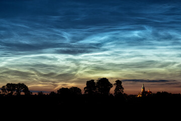 Fototapeta na wymiar Rare noctilucent clouds at summer night sky