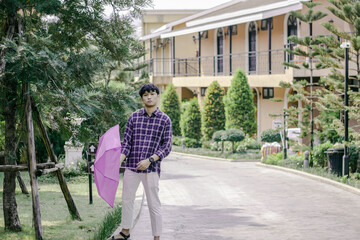 Fototapeta na wymiar Asian man raise an umbrella to protect sun, hot weather, vintage tone