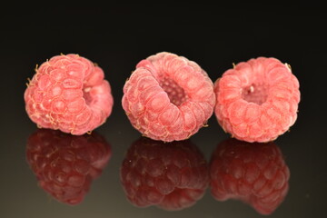 Juicy red raspberries, close-up, isolated on black.