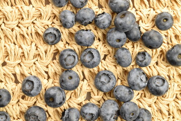 Ripe juicy organic blueberries, close-up, on a straw mat.