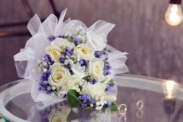 Wedding bouquet of white roses, rings, purple dry little flowers. Delicate white roses, purple...