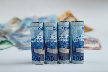 Doha, Qatar - May 03, 2020: Currencies and money exchange trading concepts. Qatari 500 ,100,50,10,5,1 Riyals Bank Note .& Coins ,Qatari Currency roll .