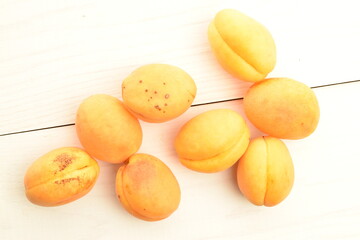 Naklejka na ściany i meble Ripe organic yellow apricot, close-up, on a wooden table.