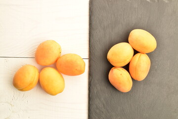 Naklejka na ściany i meble Juicy organic apricots, close-up, on a white wooden table.