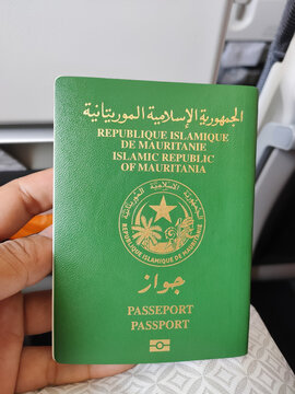 A man holding a passport of Islamic Republic of Mauritania. (Translation: Islamic Republic of Mauritania, Passport)