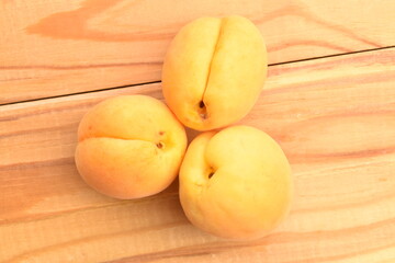 Juicy organic apricots, close-up, on a wooden table.