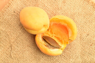 Juicy organic apricots, close-up, on a jute fabric.