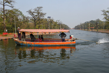 Fototapeta na wymiar Tourist boat on the canal of the monastic zone at Lumbini in Nepal