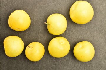 Ripe yellow plum, close-up, on a slate board.