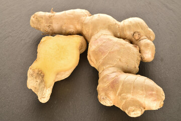 Fresh ginger root, close-up, on a slate serving board.