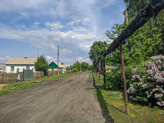 Russian village, near the road passes the heating line in Kamen-na-Obi, Altai, Russia. View.
