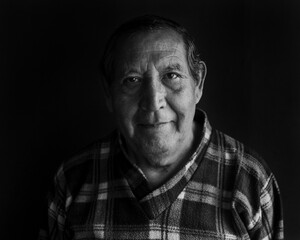 Black and white portrait of elderly Peruvian man with a melancholic gesture