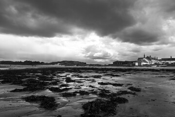 The tide has turned at Low Newton-by-the-Sea but clouds are heavy before the rain on a warm summers day.