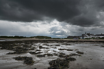 The tide has turned at Low Newton-by-the-Sea but clouds are heavy before the rain on a warm summers day.