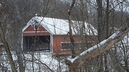 old wooden covered bridge in winter in snow
