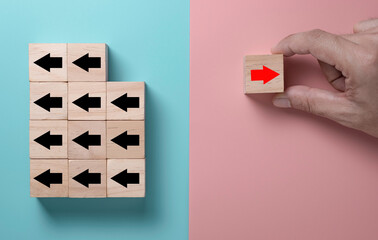 Red arrow print screen on wooden cube changing direction with black arrow. It is business disruption and different thinking idea concept.