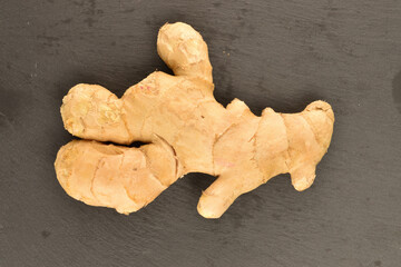 Ripe ginger root, close-up, on a slate board.