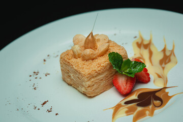 Napoleon cake with mint and strawberries on the plate