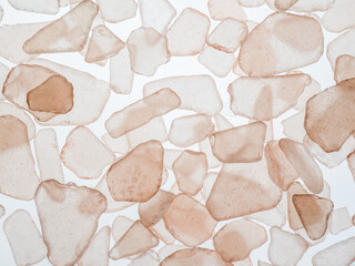 Close-up filling frame of translucent pink sea glass chips on a white background