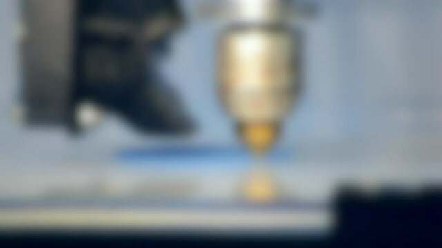 Blurred background. 3d printer printing isolated blue object close-up on