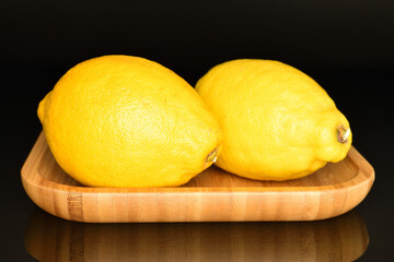 Ripe yellow lemons, close-up, on a black background.
