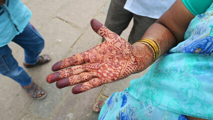 henna tattoo on hand of Indian woman wearing sari at the market
