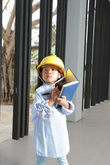 Kids and education concept, Asia kid girl posing in engineers dress with holding book and pen....