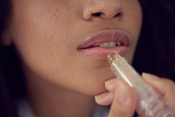 Young woman using moisturizing lipstick for treatment