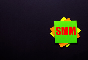 SMM is written on a bright sticker on a dark background. Business concept