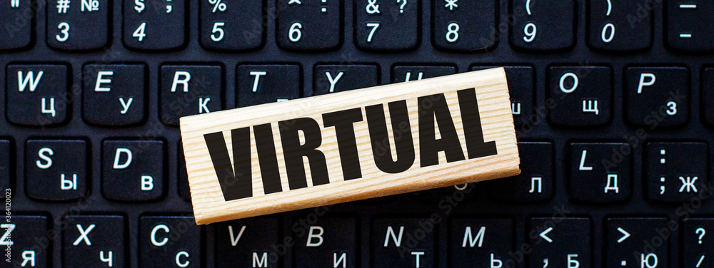 Poster the word virtual is written on a wooden block on a computer keyboard. internet concept