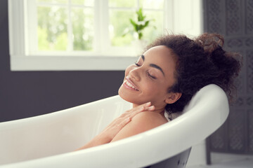 Happy young lady enjoying time alone in bathroom