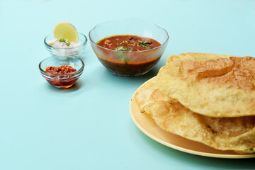 Indian dish spicy Chick Peas curry also known as Chole Bhatura and Chana Masala or Chole or Chickpeas Masala curry,traditional north indian lunch served with fried puri or flatbreads,selective focus