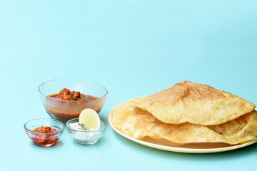 Indian dish spicy Chick Peas curry also known as Chole Bhatura and Chana Masala or Chole or Chickpeas Masala curry,traditional north indian lunch served with fried puri or flatbreads,selective focus