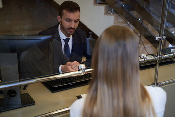 Male receptionist taking booking from the visitor