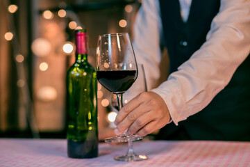 Waitress man pouring wine into glass