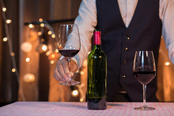 Waitress man pouring wine into glass