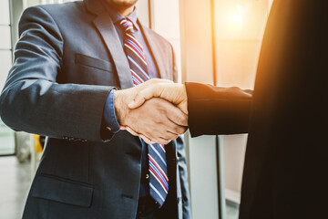 Business people handshake in corporate office showing professional agreement on a financial deal...