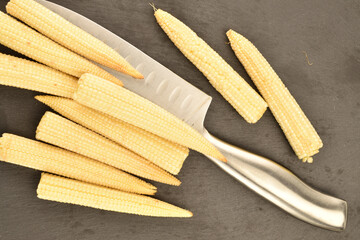 Sweet ripe mini corn, close-up, on a slate board.